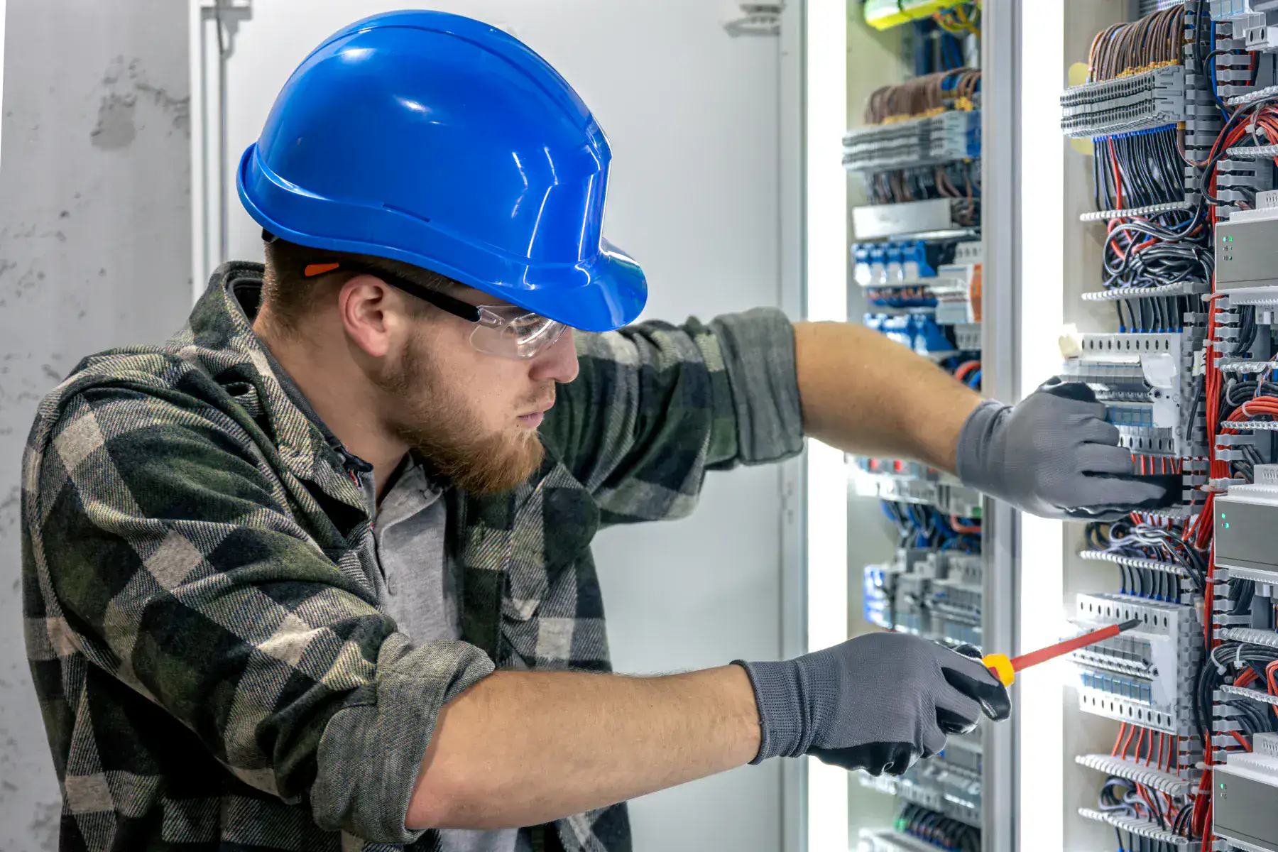 Électricien contrôlant un tableau électrique résidentiel avec un multimètre