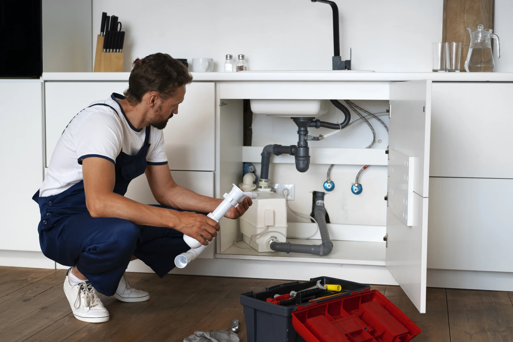 Plombier installant un lavabo et sa robinetterie dans un appartement