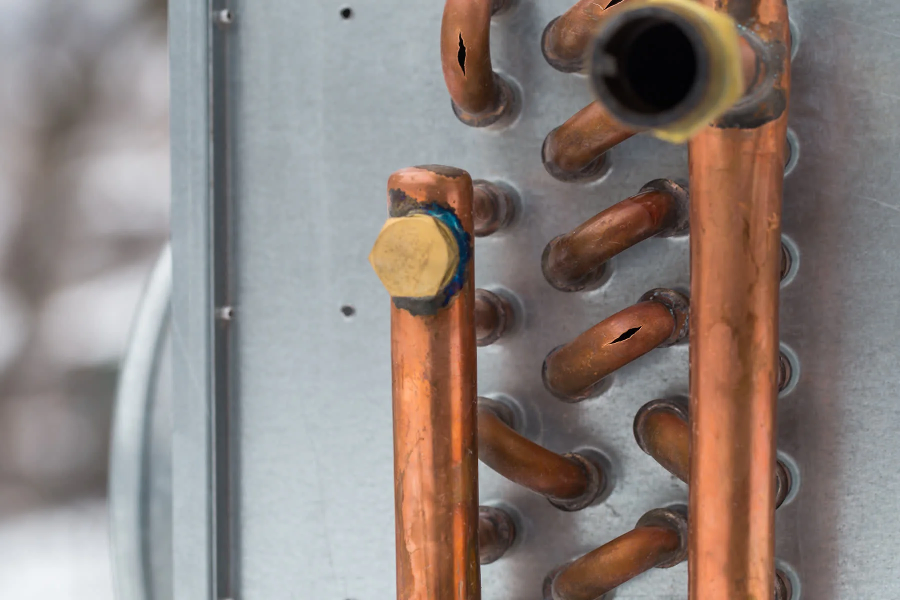 Chauffagiste vérifiant un radiateur sous une fenêtre